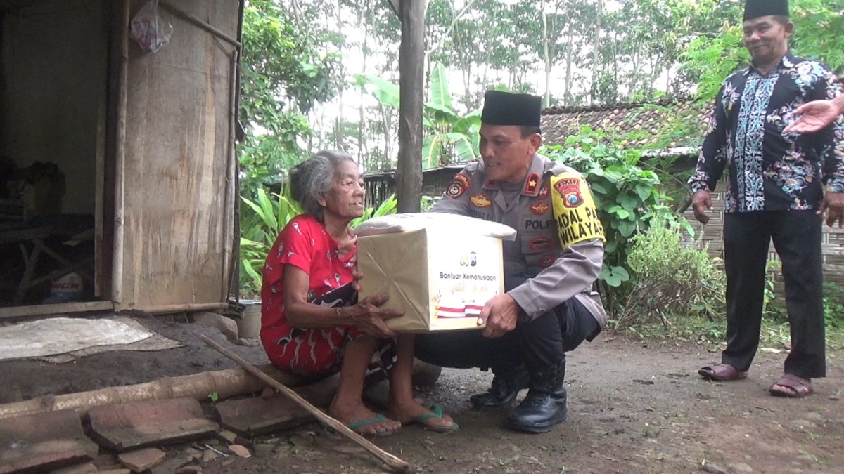 Polisi saat memberikan bantuan paket sembako kepada Sarmi, lansia yang hidup sendirian di rumahnya di Desa Kedunglumpang, Kecamatan Mojoagung (Foto: Elok Aprianto/jatimnow.com)