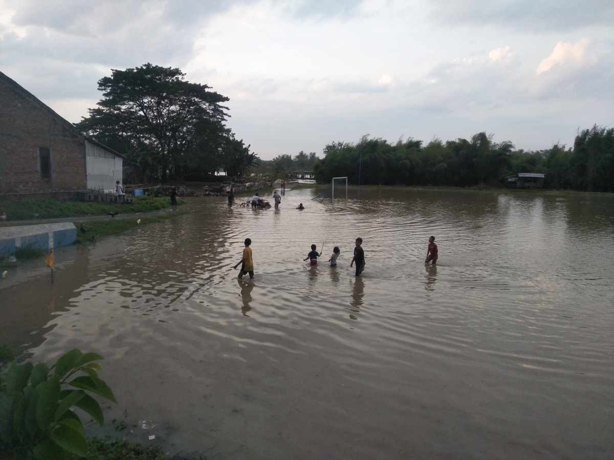 Sejumlah anak anak terlihat asik bermain air di lapangan yang terendam luapan air Sungai Bengawan Solo Bojonegoro (Foto-foto: Misbahul Munir/jatimnow.com)