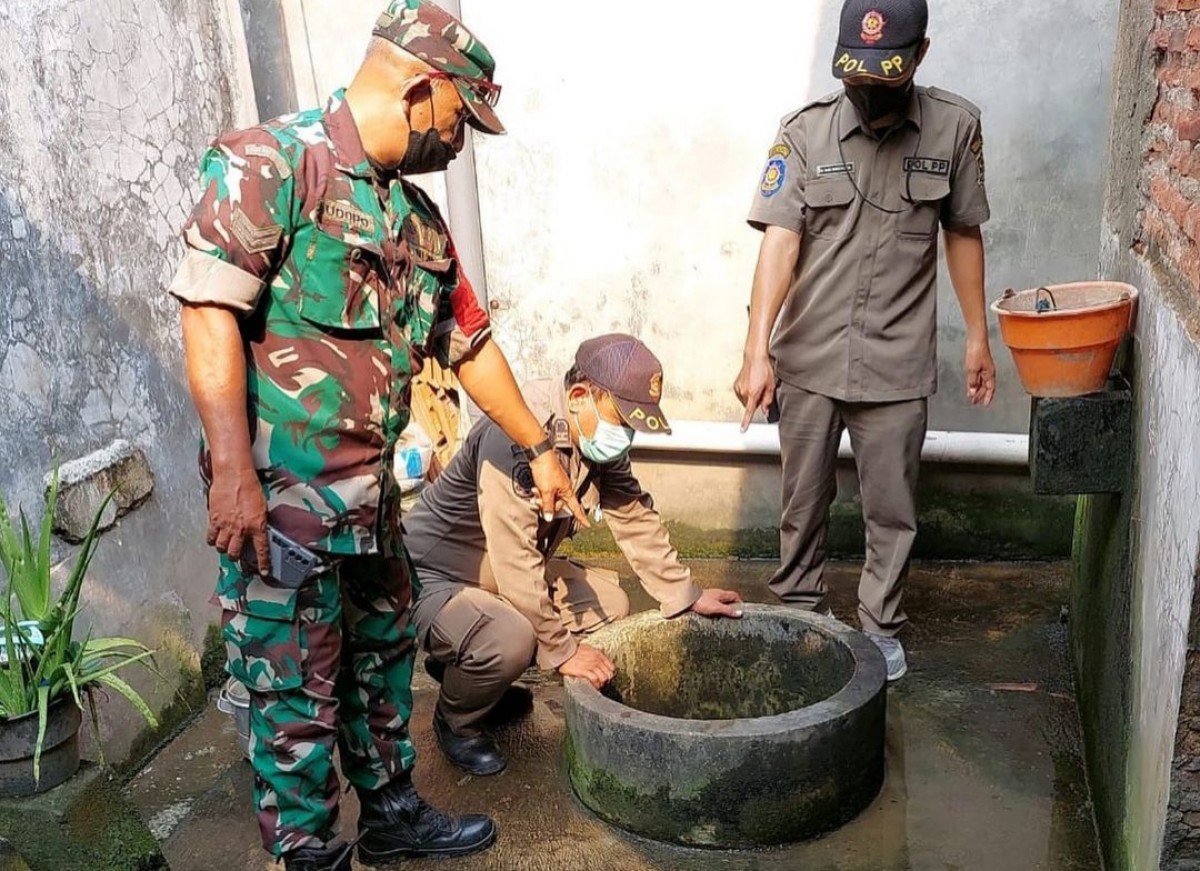 Petugas menunjukkan sumur, tempat ditemukan pemuda tewas di dalamnya (Foto: BPBD Surabaya for jatimnow.com)