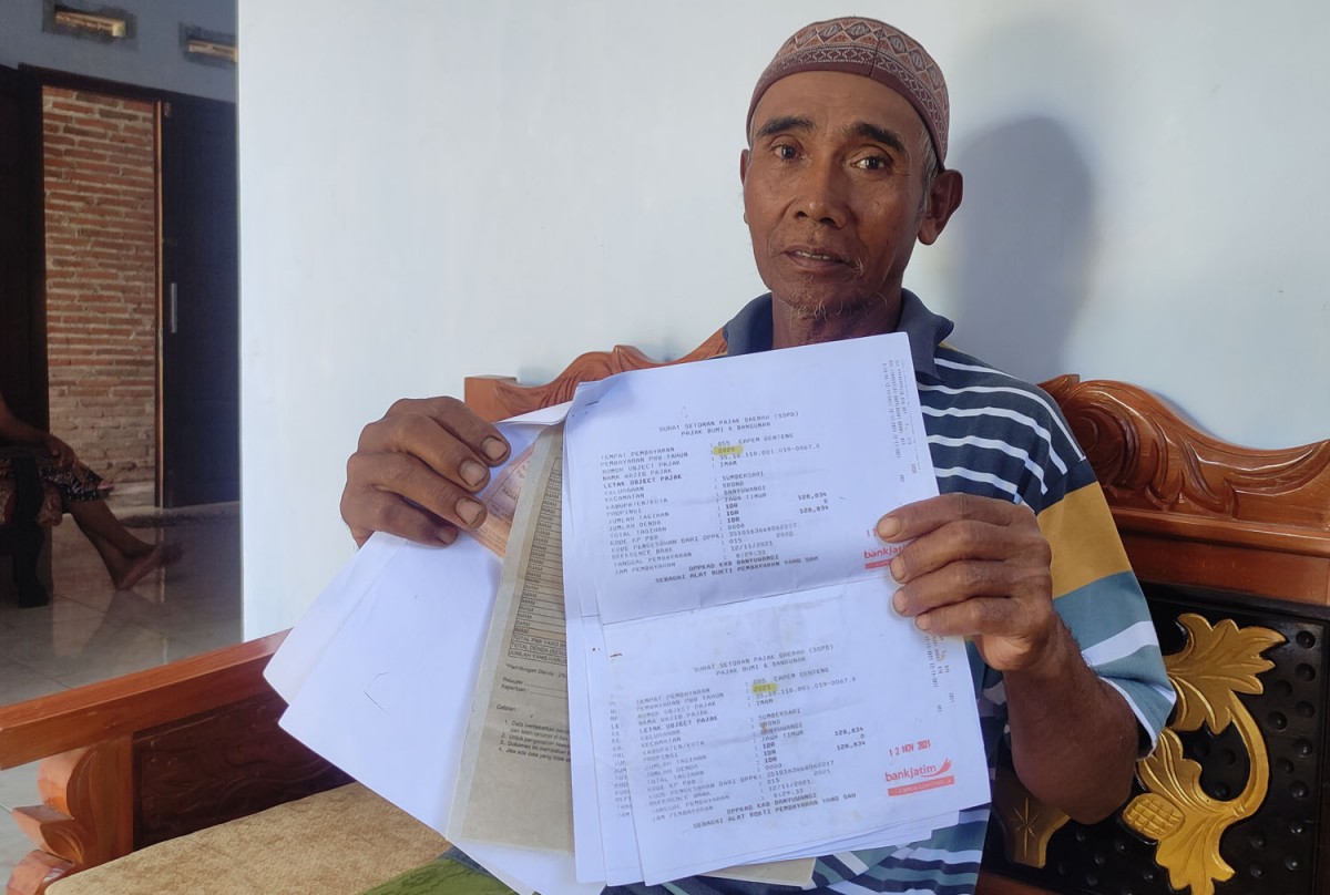 Imam Hajadi menunjukkan bukti pembayaran PBB dari Bank Jatim (Foto: Eko Purwanto/jatimnow.com)