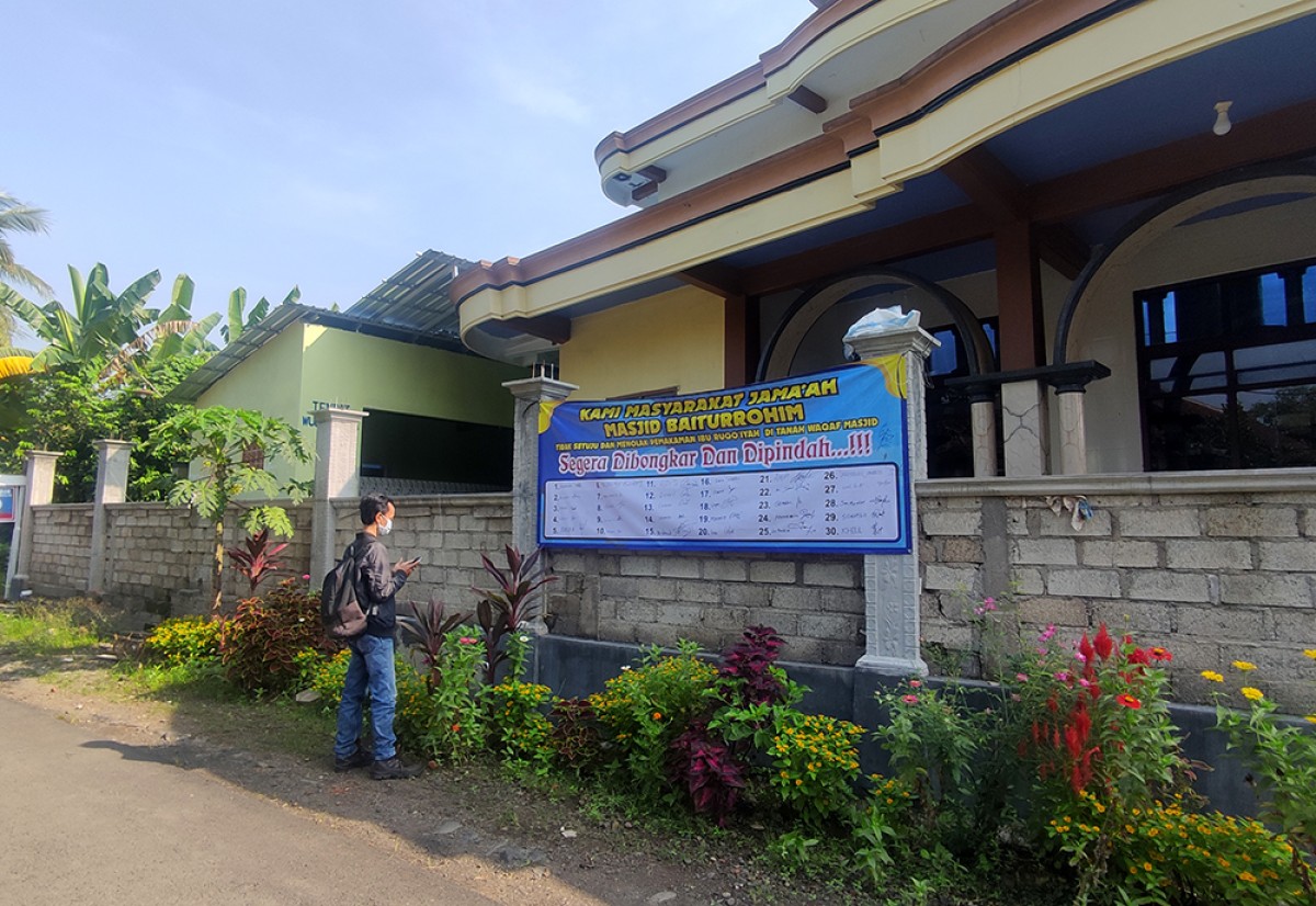 Spanduk penolakan makam yang berdiri di lahan Masjid Baiturrohim oleh warga Banyuwangi. (foto: Eko Purwanto/jatimnow.com)