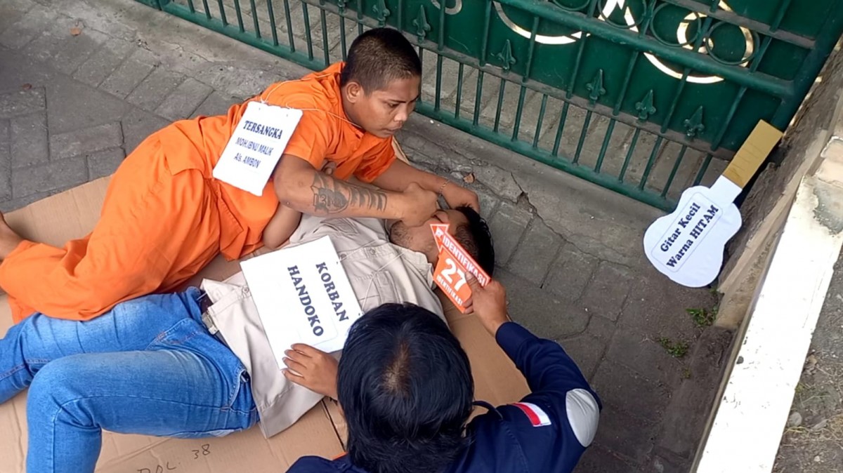 Tersangka saat menjalani rekontruksi pembunuhan rekan sesama pengamen. (foto: Bramanta Pamungkas/jatimno.com)