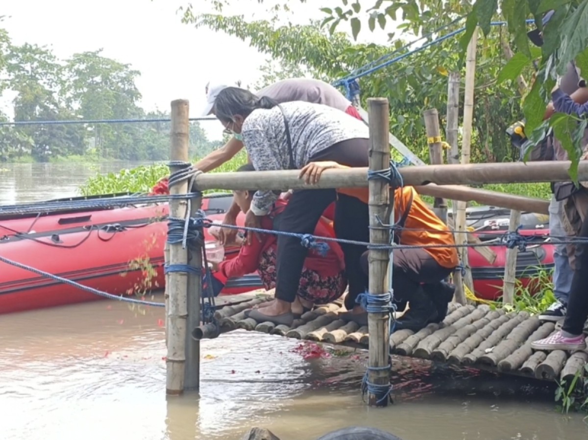 Keluarga Desiree Peni Chindy Khatrine melakukan tabur bunga di Sungai Brantas, Jalan Mastri Surabaya. (foto: Rama Indra Surya/jatimnow.com)