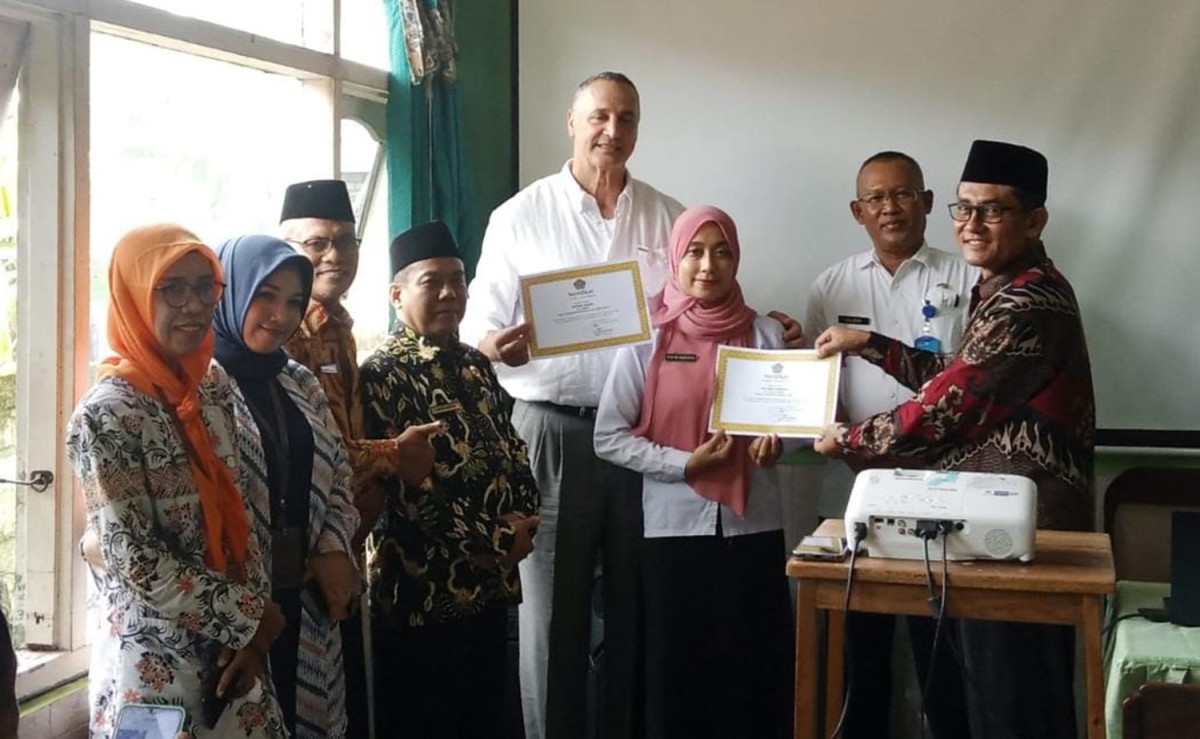 Ezedin Akari, WN Australia bersama pasangannya Eni Muji Rahayu saat menerima piagam bimbingan nikah dari Kemenag Tuban (Foto: Agus for jatimnow.com)