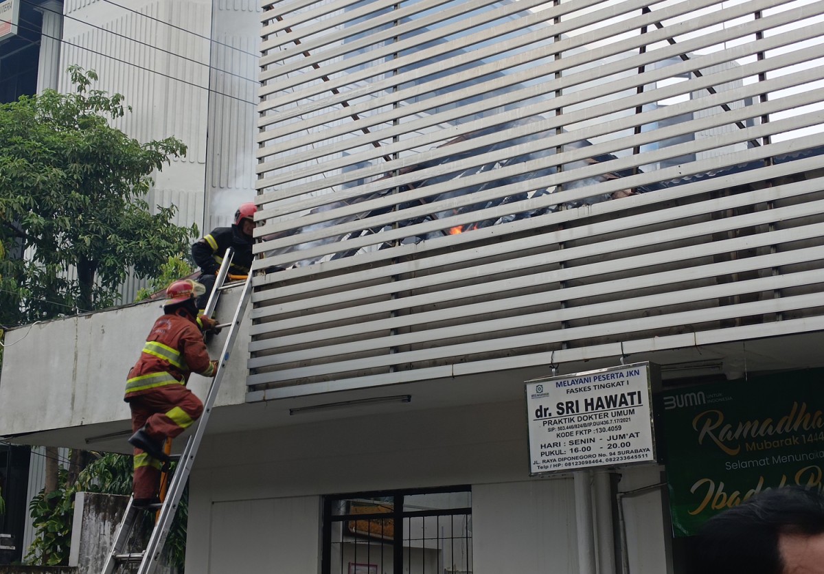 Petugas pemadam berusaha memadamkan api di Apotek Kimia Farma Jalan Diponegoro Surabaya (Foto: Rama Indra/jatimnow.com)