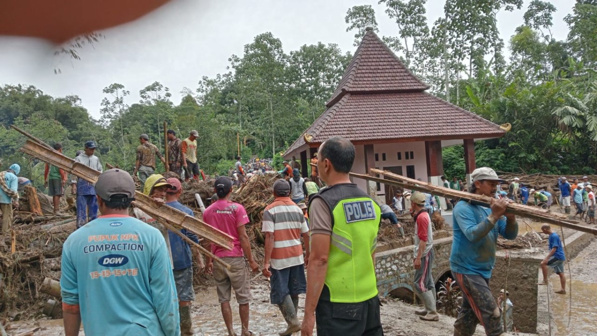 Warga di Ngantang, Batu membersihkan material akibat banjir bandang. (foto: Galih Rakasiwi/jatimnow.com)