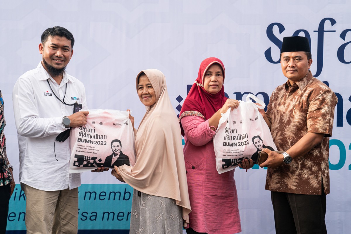 Partnership Program & Comdev Senior Officer SIG, Amin Budi Hartanto (kiri) dan Camat Pamulang, Mukroni (kanan) menyerahkan sembako murah kepada warga pada kegiatan Safari Ramadan BUMN 2023 di halaman Kantor Kecamatan Pamulang, Tangsel