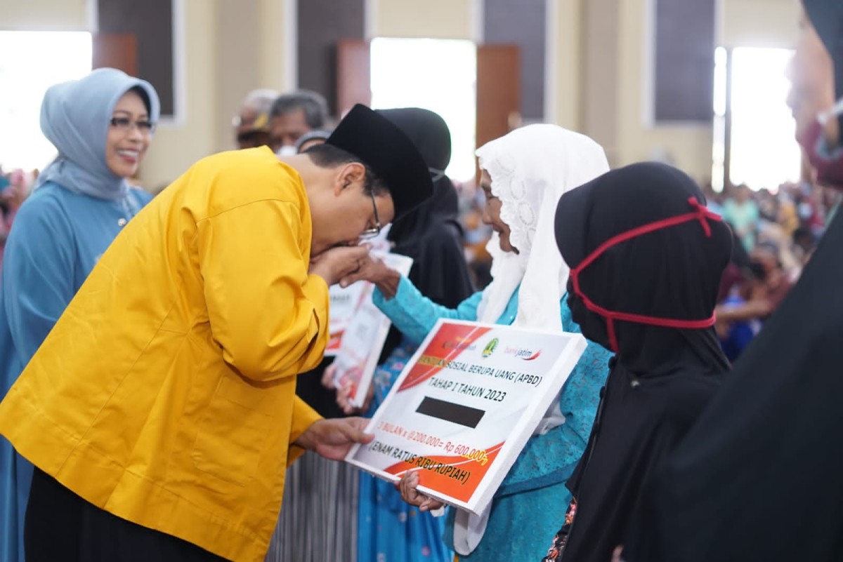Gus Ipul mencium tangan warganya saat menyerahkan bantuan untuk KPM. (foto: Humas Pemkot Pasuruan for jatimnow.com)