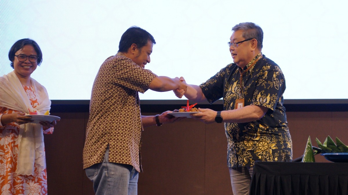 Rektor Universitas Ciputra Surabaya, Ir. Yohannes Somawiharja, M.Sc., (kanan) memberikan potongan tumpeng kepada Kepala LPPM UC di acara ucapan syukur pencapaian UC.
