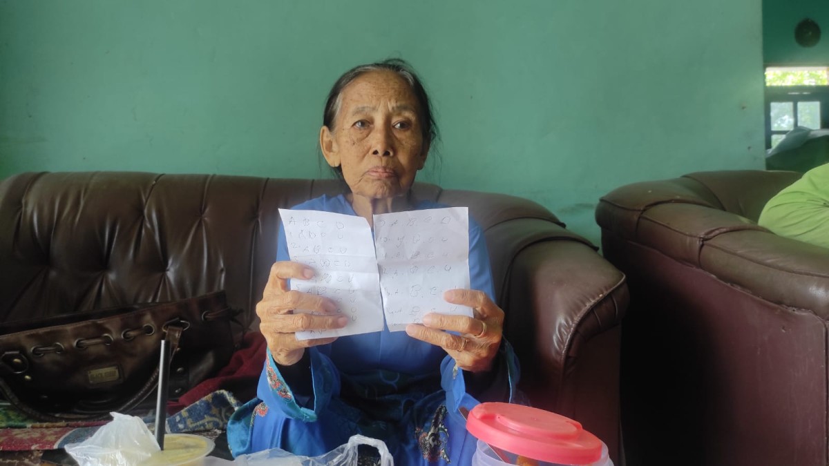 Nenek Giyem (70) memperlihatkan kertas berisi kuisioner yang jadi modus operandi pelaku pencurian emas miliknya. (Foto: Eko Purwanto/jatimnow.com)