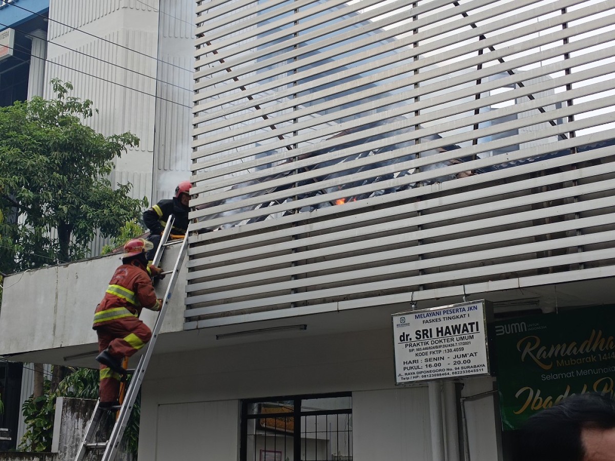 Petugas berusaha memadamkan api di apotek Kimia Farma Jalan Diponegoro. (Foto: Rama Indra/jatimnow.com)