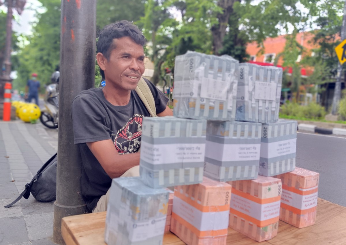 Mad, asal Sampang saat membuka lapak penukaran uang baru di Jalan Bubutan, Surabaya (Foto: Rama Indra/jatimnow.com)