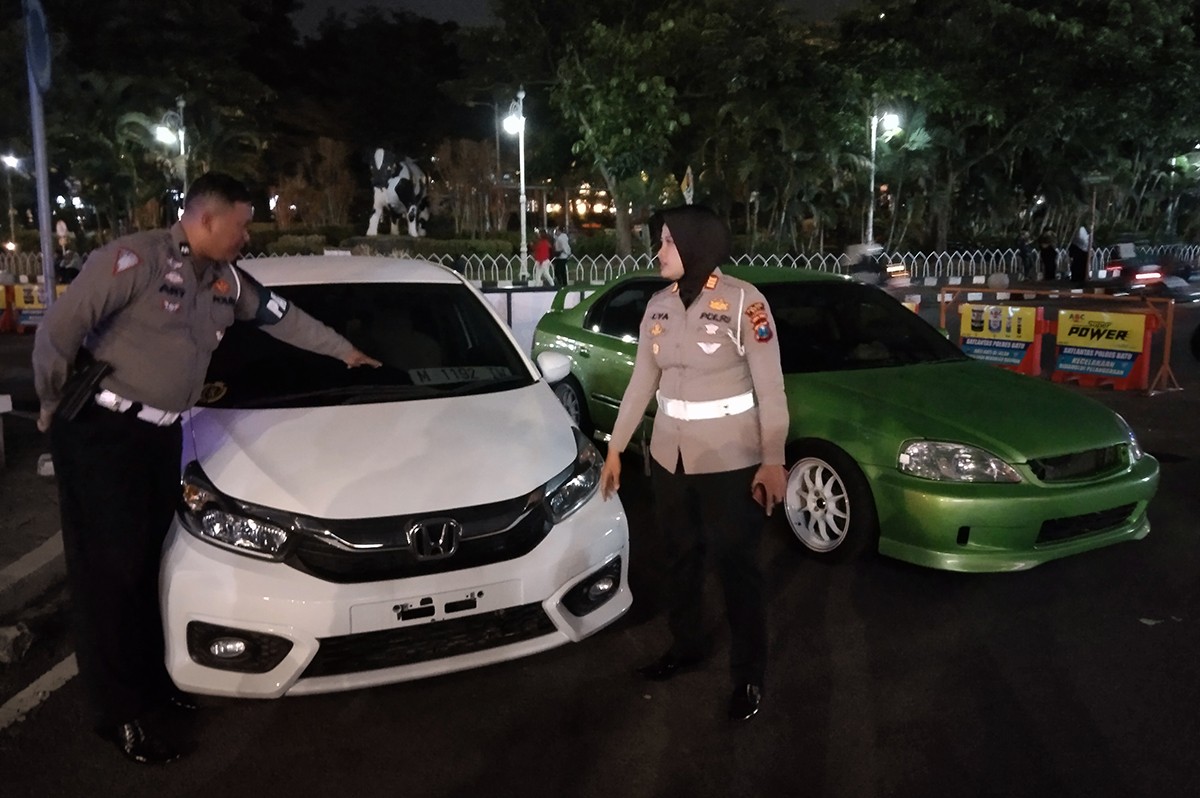 Kasatlantas Polres Batu, AKP Lya Ambarwati mengecek dua mobil yang diamankan. (Galih Rakasiwi/jatimnow.com)
