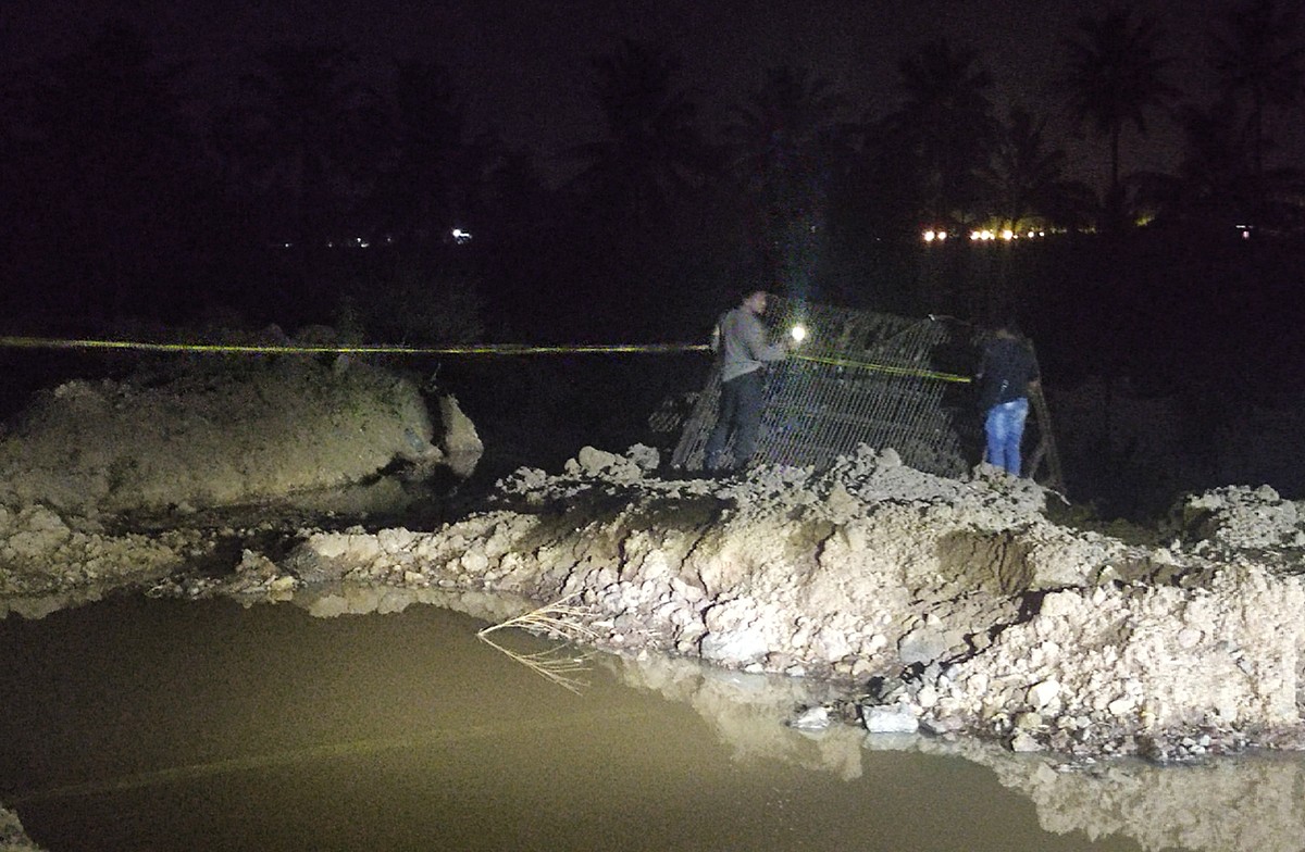 Pemasangan garis polisi di kolam galian C yang menewaskan tiga bocah perempuan di Banyuwangi. (foto: Eko Purwanto/jatimnow.com).