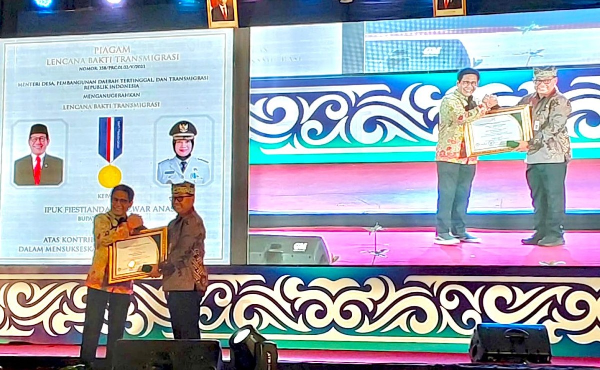 Menteri Desa Pembangunan Daerah Tertinggal dan Transmigrasi Abdul Halim Iskandar menyerahkan penghargaan kepada Sekretaris Kabupaten (Sekkab) Mujiono yang mewakili Bupati Ipuk.(foto: Humas Pemkab Banyuwangi for jatimnow.com)