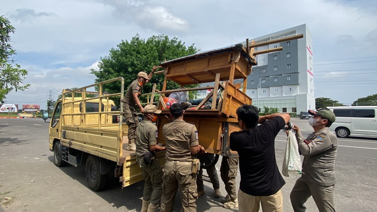 Satpol PP Kabupaten Kediri mengangkut gerobak-gerobak angkringan di kawasan SLG. (Foto: Yanuar Dedy/jatimnow.com)