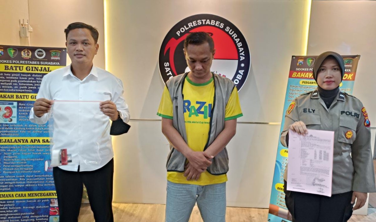 Tersangka RJP diapit petugas Satnarkoba Polrestabes Surabaya. (foto:Satnarkoba Polrestabes Surabaya for jatimnow.com)