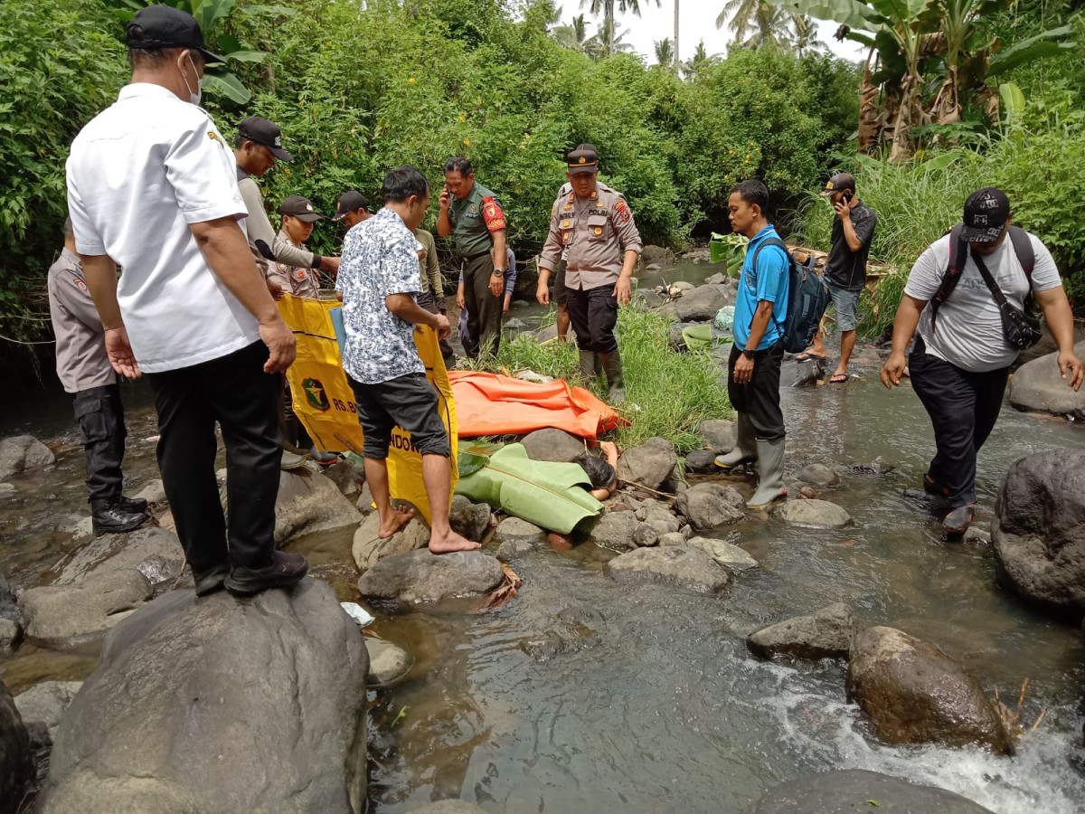 Proses evakuasi jenazah korban oleh anggota kepolisian dibantu warga. (foto: Eko Purwanto/jatimnow.com)