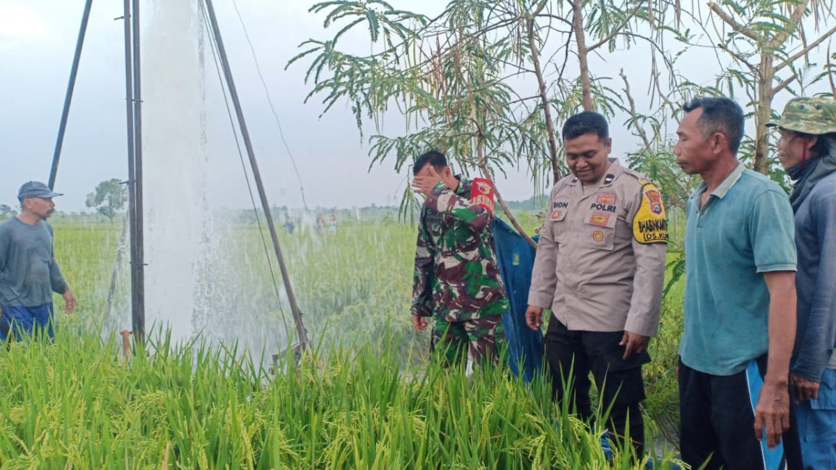 Petugas kepolisian dan TNI bersama perangkat desa saat meninjau lokasi semburan air. (Foto: Polsek Dander)