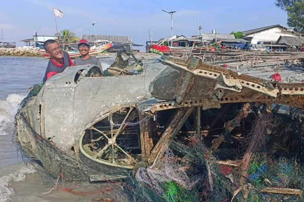 Warga setempat saat melihat secara seksama bangkai kapal yang berhasil di bawah ke kepi pantai. (Foto: Adyad Ammy Iffansah/jatimnow.com)