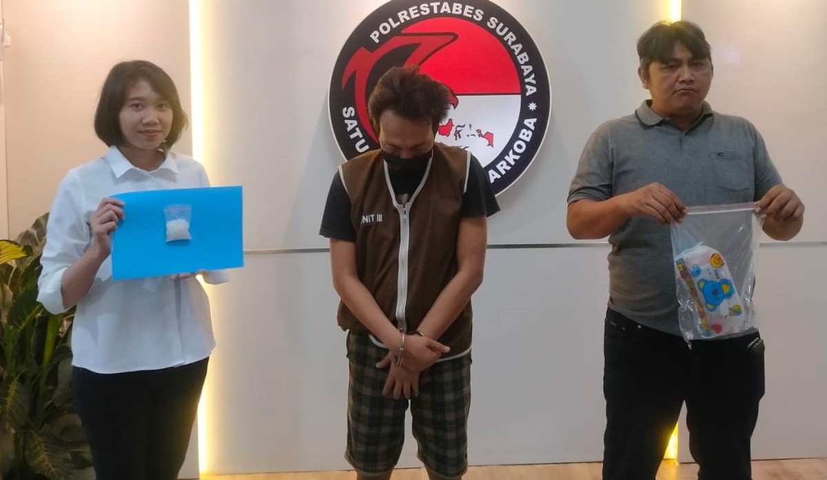 Tersangka El diapit anggota Satnarkoba Polrestabes Surabaya.(foto: Satnarkoba Polrestabes Surabaya for jatimnow.com)