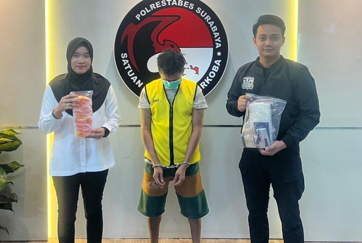 Tersangka AA diapit polisi menunjukkan barang bukti.(foto:Fahrizal Tito/jatimnow.com)