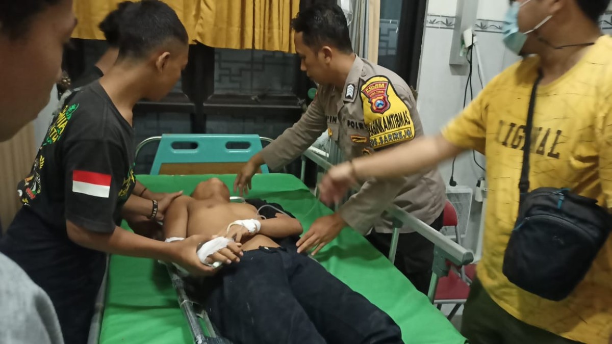 Salah satu korban yang terjatuh dari truk mendapat perawatan medis.(foto: Misbahul Munir/jatimnow.com)