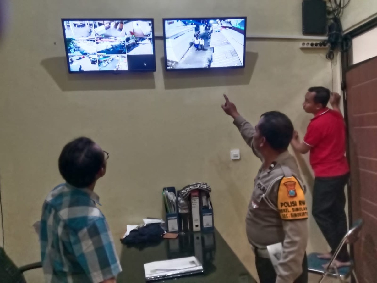 Aipda Abdul Fatah, anggota Unit Lantas Polsek Simokerto yang juga sebagai Polisi RW saat mengecek CCTV usai menggagalkan pencurian motor. (foto: Polsek simokerto for jatimnow.com).