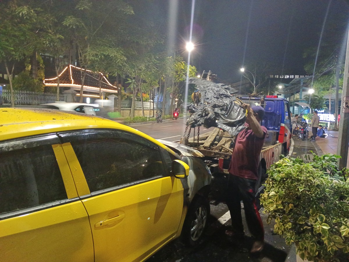 Honda Brio yang bagian depannya terbakar akan dievakuasi menggunakan mobil derek.(Foto: Rama Indra)
