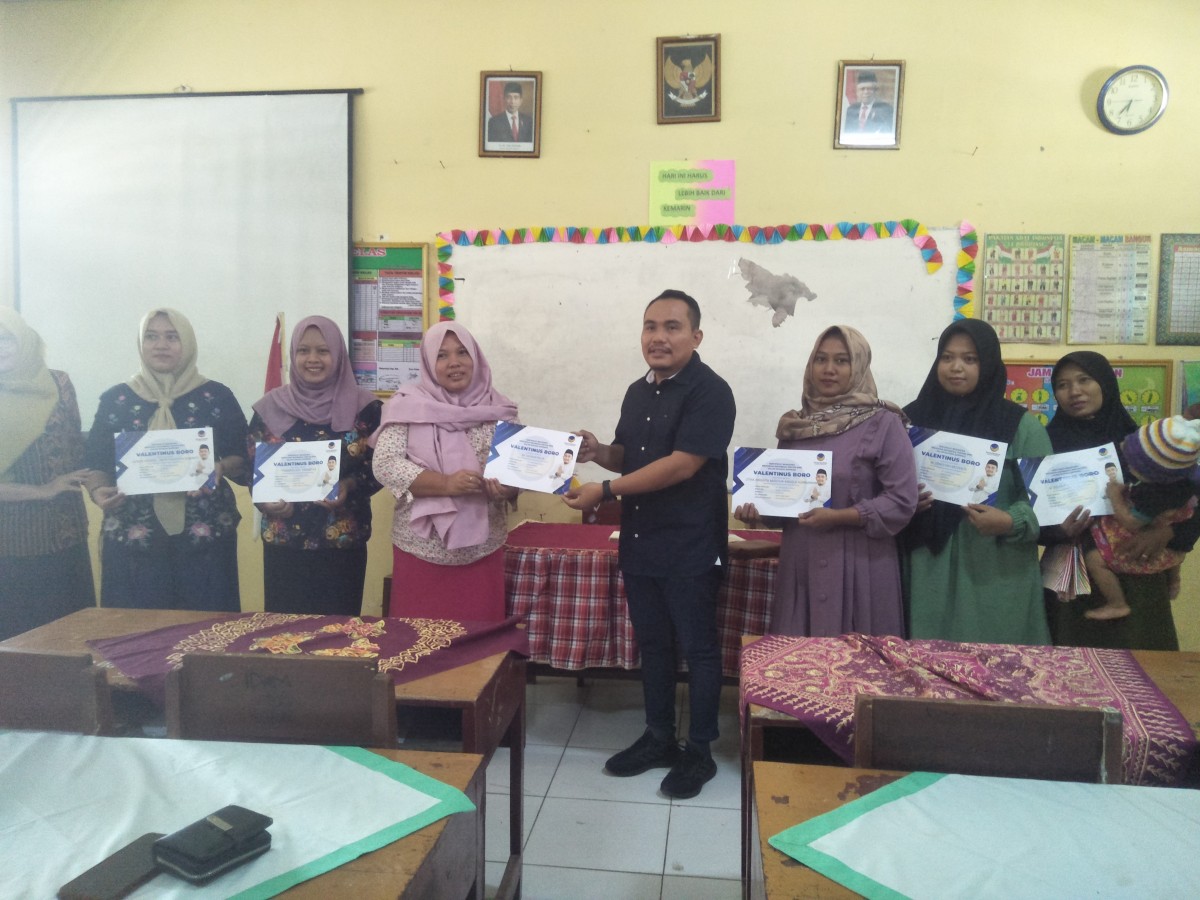 Valentinus Boro secara simbolis menyerahkan bantuan PIP kepada orang tua siswa di SDN 2 Malo. (Foto: Misbahul Munir/jatimnow.com)