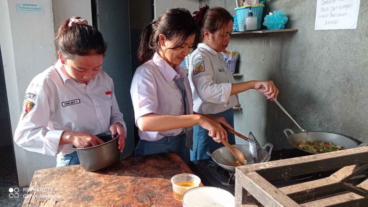 Anak kos Griya Amanah sedang memasak bersama. (Foto: Ahmad Fauzani/jatimnow.com)