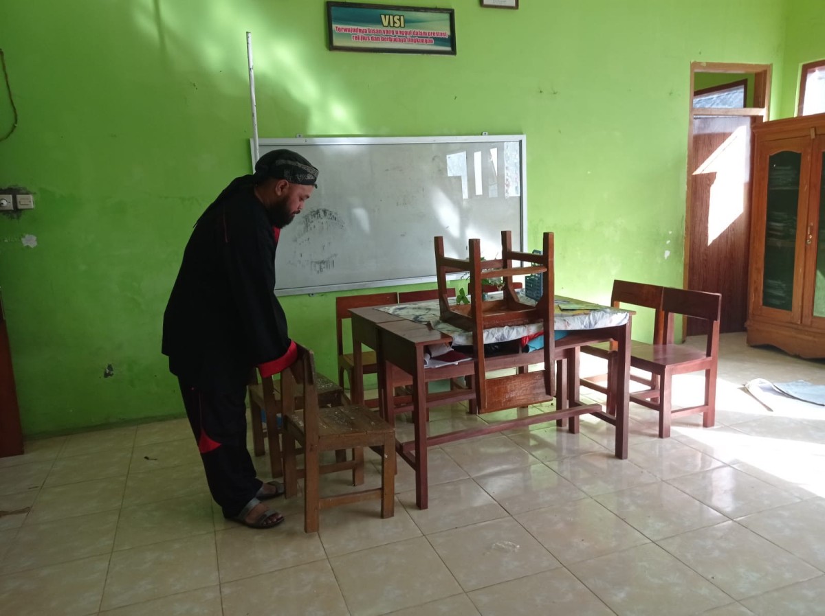 Kepala SDN Jalen, Dedy Ady Nugroho saat menata kursi di ruang kelas 1 (Foto: Ahmad Fauzani/jatimnow.com)