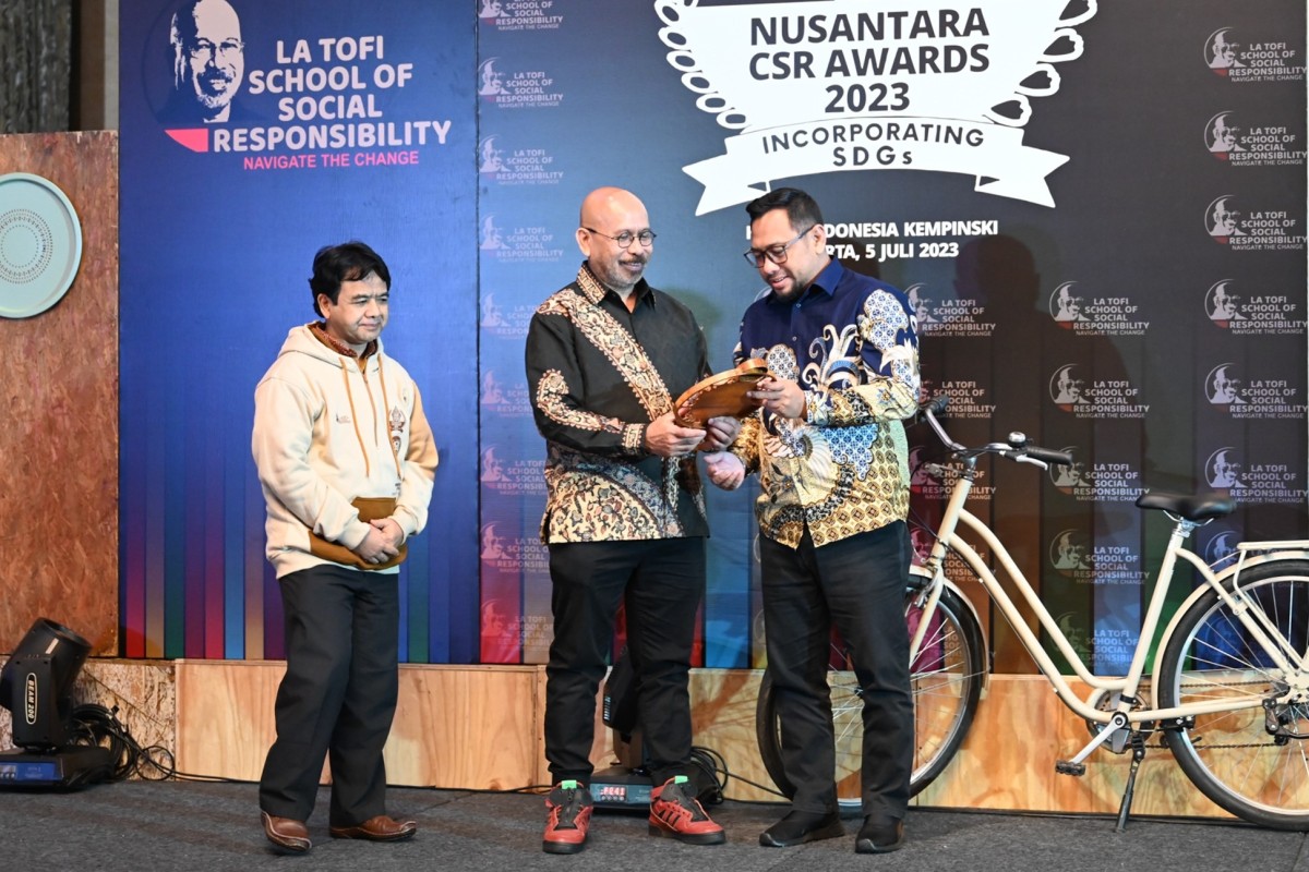 Chairman La Tofi School of Social Responsibility, La Tofi (tengah) menyerahkan Penghargaan Nasional CSR SDGs predikat Platinum kepada CSR Monitoring dan Evaluation Officer SIG, Rahmad A. Perdana (kanan) dalam ajang Nusantara CSR Awards 2023 di Hotel Indon