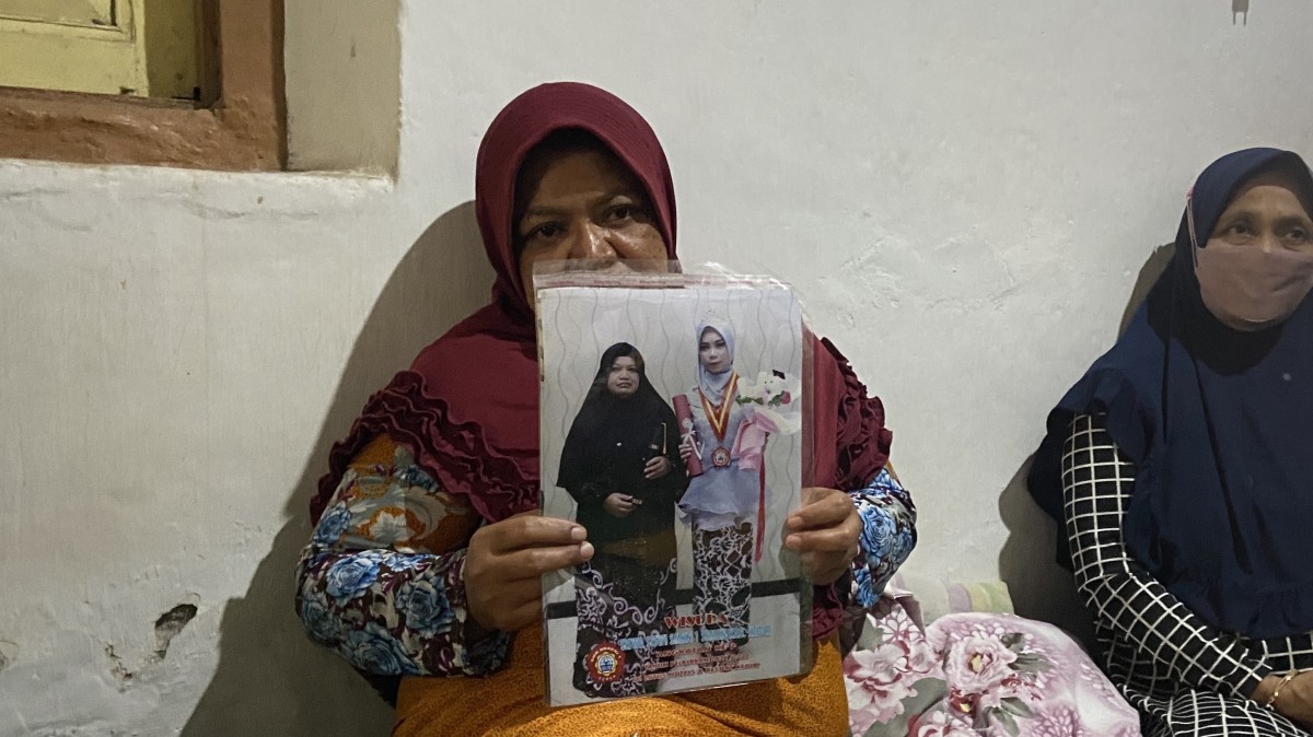 Sulastri, ibu mayat terbungkus karung memegangi potret dirinya bersama Ela. (Foto: Yanuar Dedy/jatimnow.com)