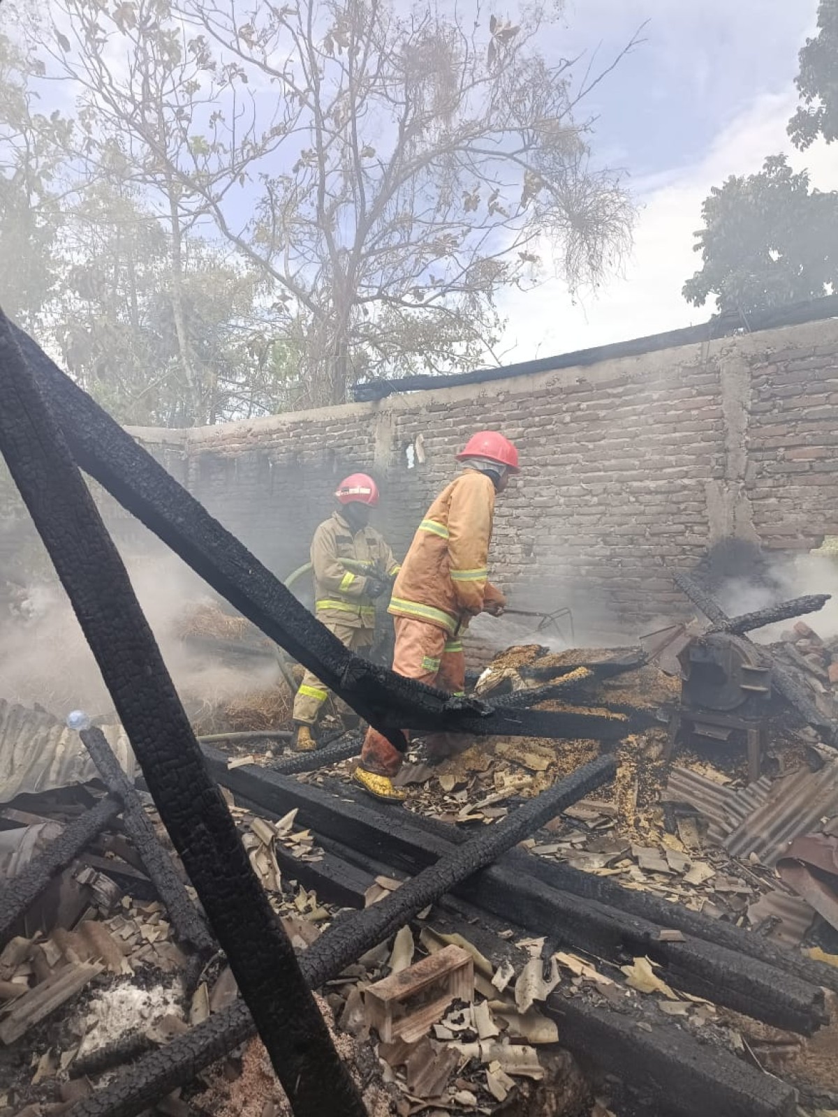 Petugas damkar saat melakukan pembasahan di tempat kejadian. (Foto : Damkar Lamongan for jatimnow.com)