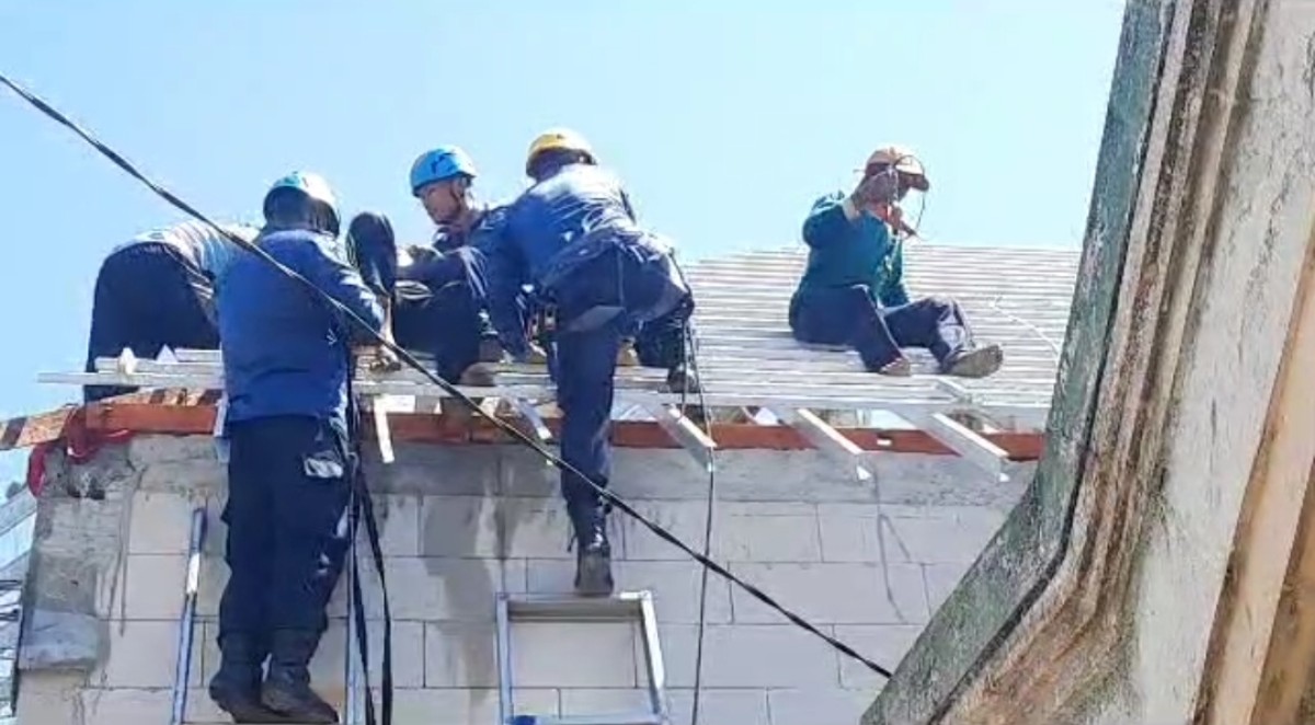 Tangkap layar video amatir warga saat sejumlah petugas Damkarmat Bojonegoro melakukan proses evakuasi kuli bangunan yang tersengat listrik. (Foto: Misbahul Munir/jatimnow.com)