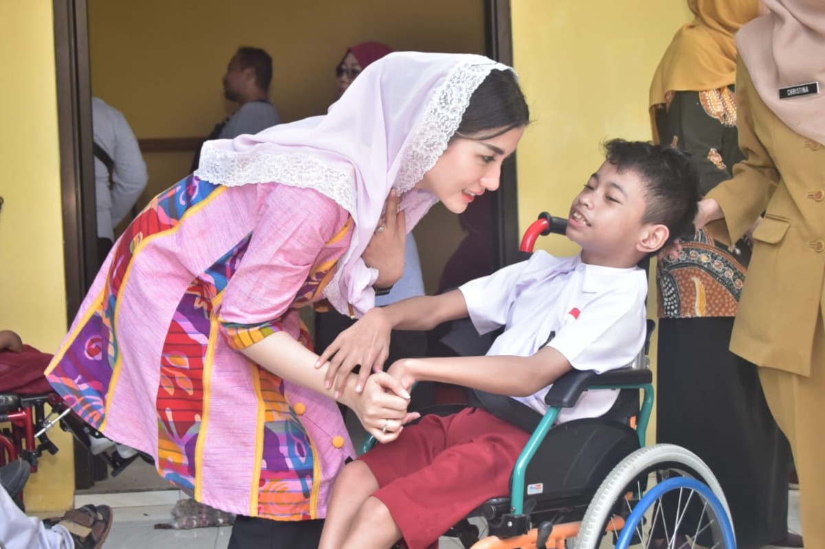 Ketua TP PKK Trenggalek, Novita Hardini saat bermain dengan anak berkebutuhan khusus. (Foto : Prokopim Trenggalek for jatimnow.com)