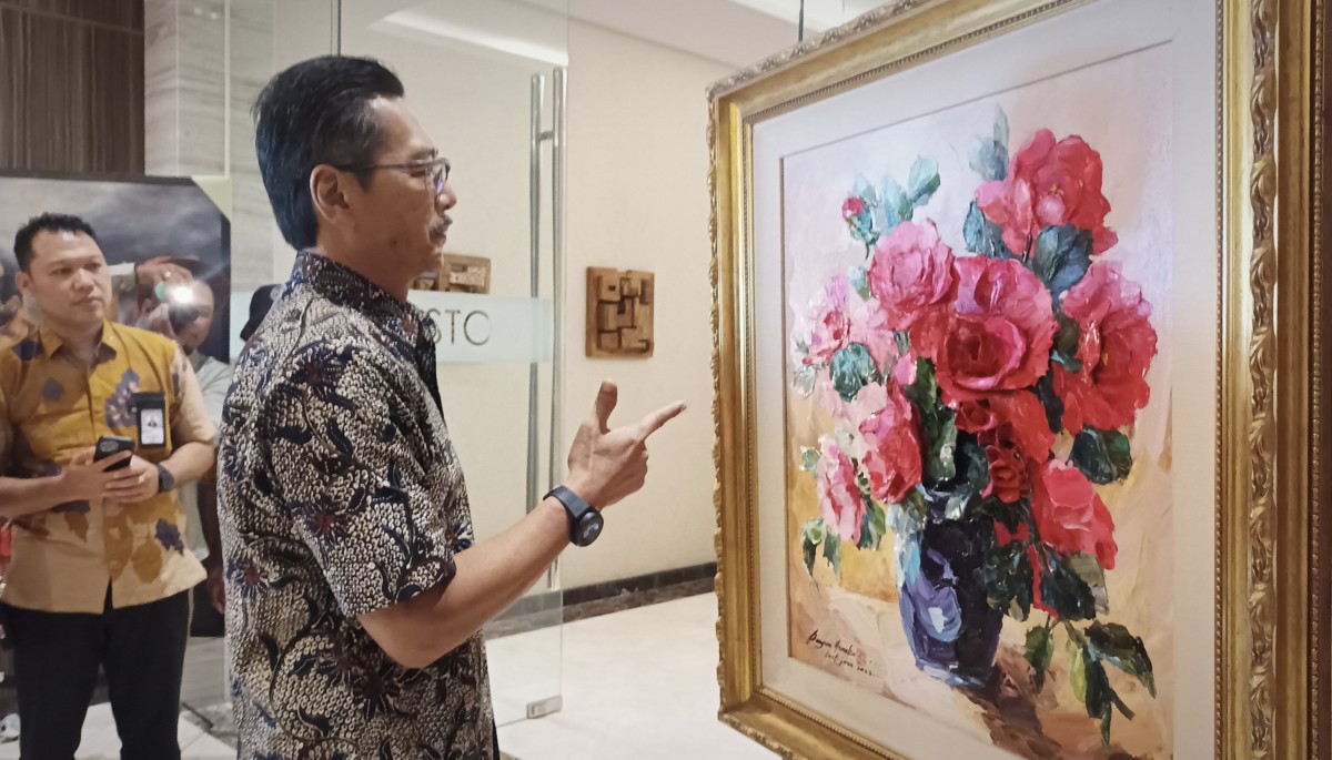 Dirut PT Dharma Lautan Utama Holding, Erwin H Poedjono, saat mengamati karya lukis di pameran The Energy of Colours (Foto: Sahlul Fahmi/jatimnow.com)