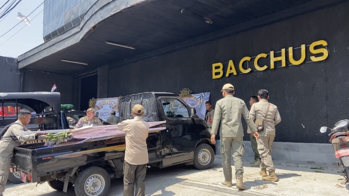 Satpol PP Kota Kediri bersihkan karangan buka di halaman Bacchus. (Foto: Yanuar Dedy/jatimnow.com)