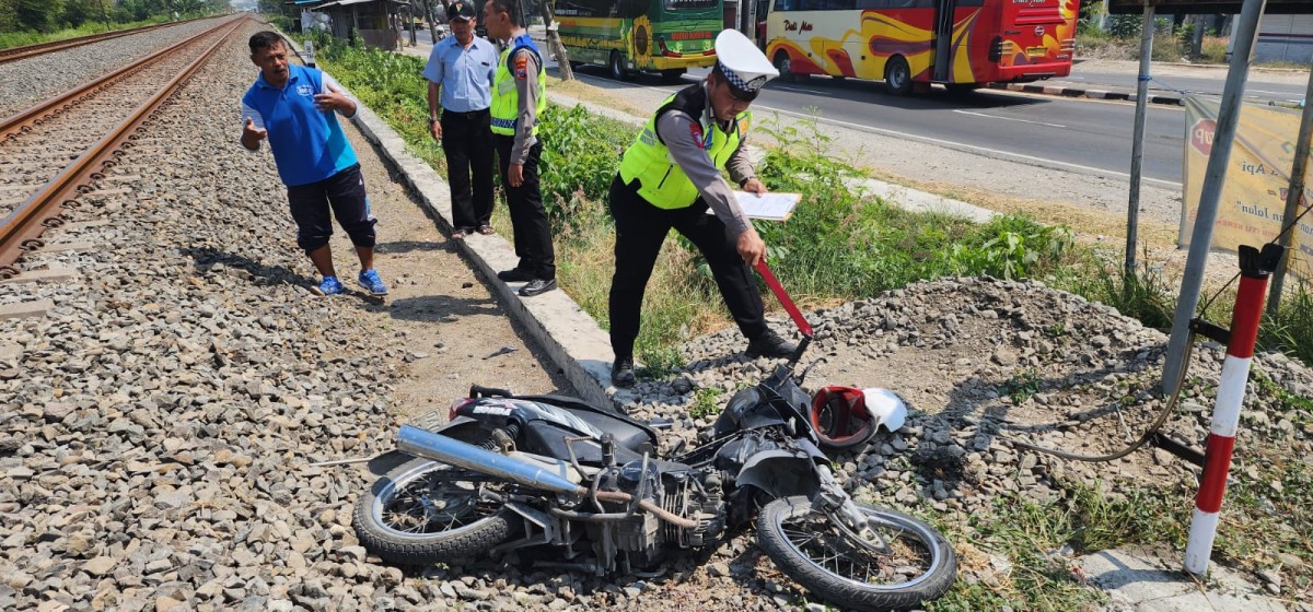 Polisi saat menggali keterangan saksi dan menunjukan kondisi motor korban tabrakan KA di Lamongan. (Foto : Adyad Ammy Iffansah/jatimnow.com)
