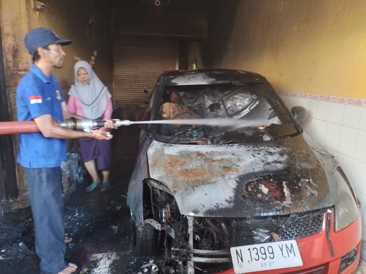 Pembasahan terhadap kendaraan yang hangus terbakar. (Foto: Fathor Rahman/jatimnow.com).