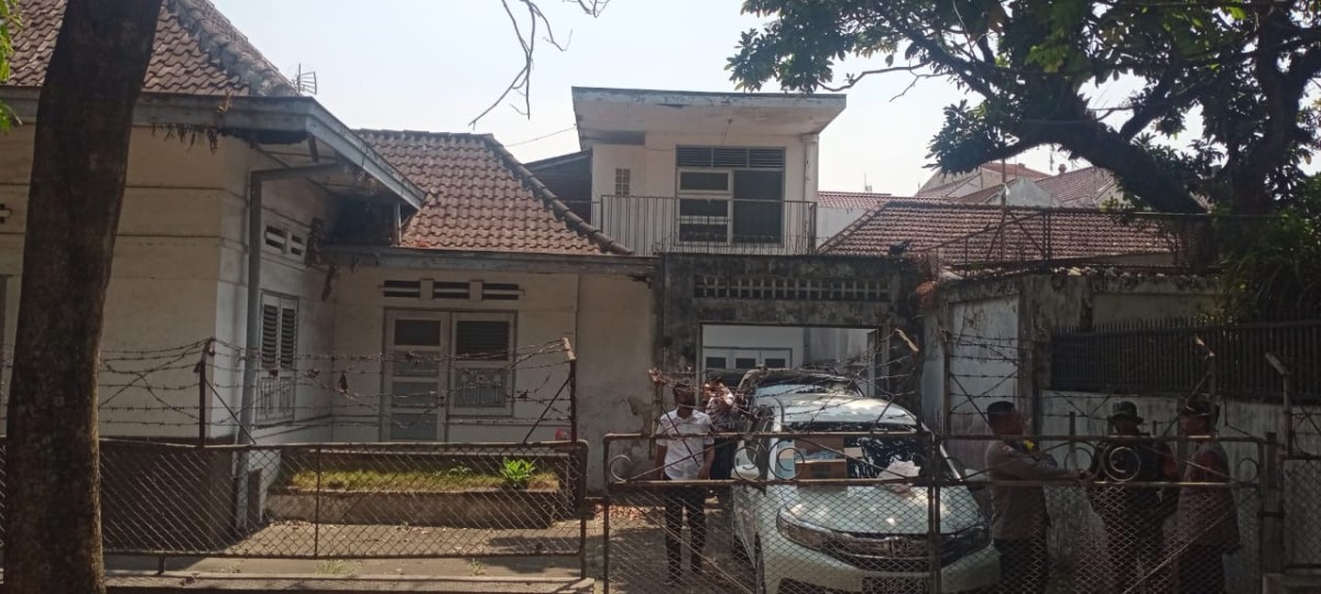 Petugas melakukan penjagaan saat menggeledah sebuah rumah. (Foto: Achmad Titan/jatimnow.com)