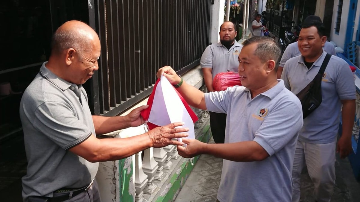 Anggota PWI Tulungagung saat membagikan bendera dan membantu memasang bendera. (Foto: Bramanta Pamungkas/jatimnow.com)
