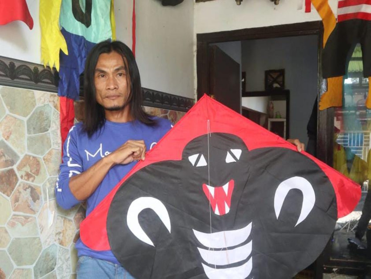 Fery menunjukkan layangan karakter hasil karyanya. (Foto: Bramanta Pamungkas/jatimnow.com)