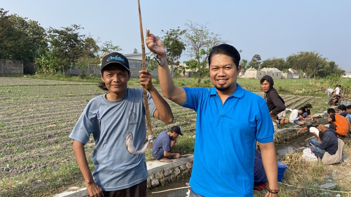 Yacob Bastian (baju biru) bersama peserta mancing lele gratis di Wonojoyo Gurah. (Foto: Yanuar Dedy/jatimnow.com)