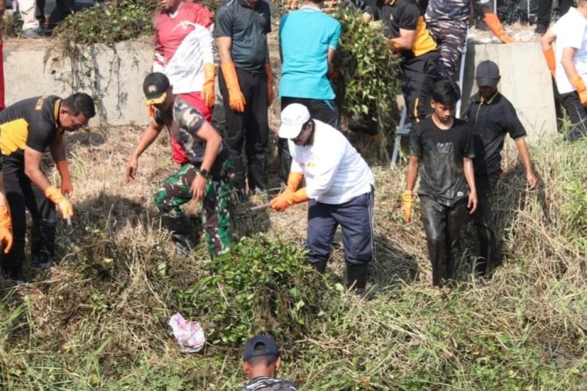Personil TNI Lanal Batuporon turun ke lapangan untuk membersihkan sungai di Bangkalan. (Foto: Fathor Rahman/jatimnow.com)