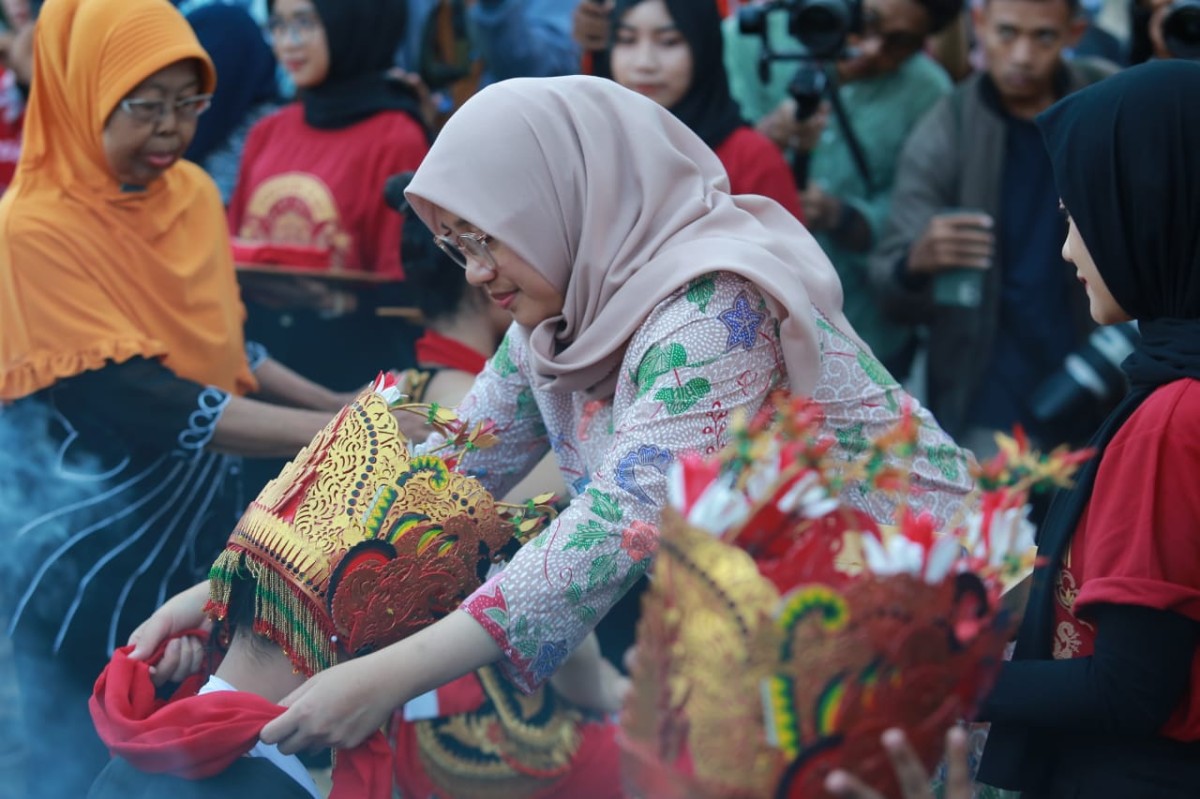 Bupati Ipuk saat memakaikan omprog. (Foto: Humas Pemkab Banyuwangi)
