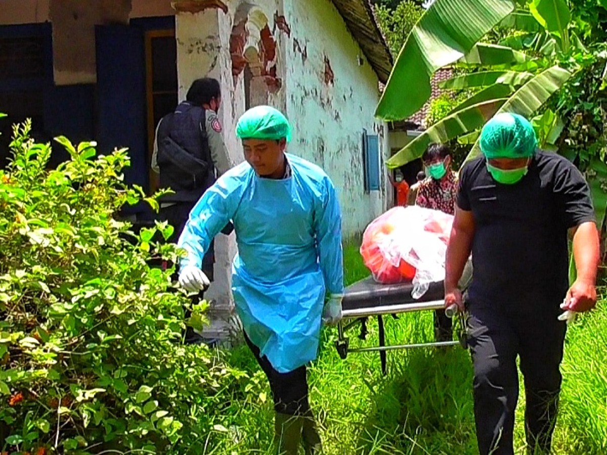 Petugas mengevakuasi jenazah Mbah Uli dari lokasi penemuan. (Foto: Fajar for jatimnow.com)