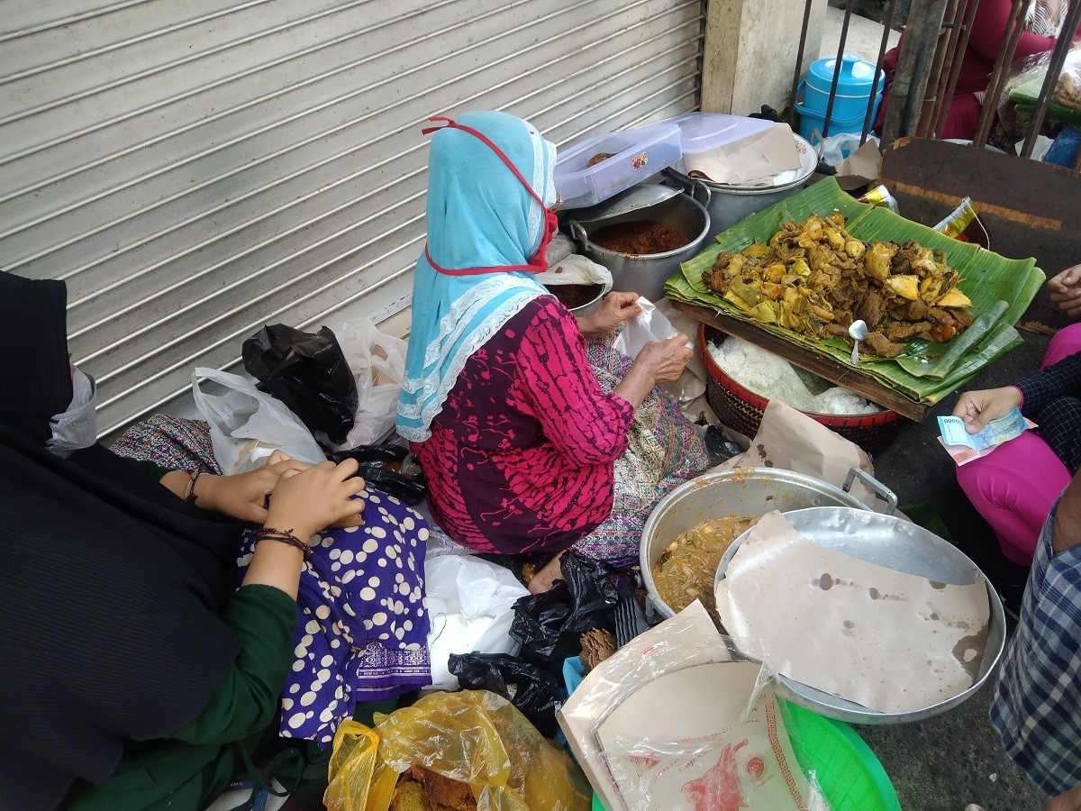 Hj Tuni saat meladeni pelanggan. (Foto: Achmad Titan/jatimnow.com)