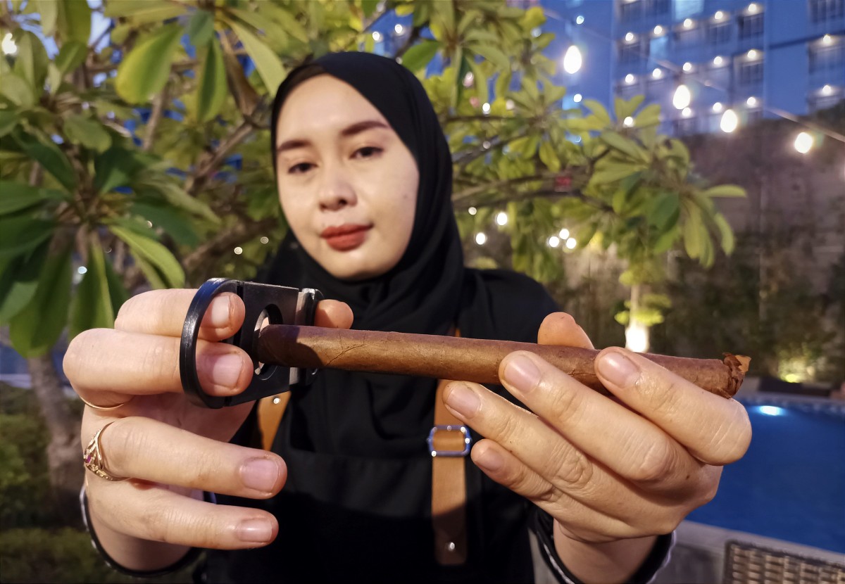 Customer service Wismilak saat memotong cerutu untuk para member (Foto: Sahlul Fahmi/jatimnow.com)